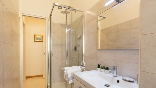 A modern bathroom with a glass shower enclosure, a white sink, and a mirror. - notaMi - Wonderhome - Bolivar M4 (Milan)