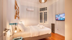 A modern bedroom with a bed, a TV, and a unique wall art piece. - Historic 2BR Oasis in Kolonaki (Athina)