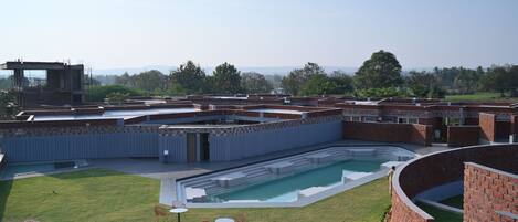Un área de piscina con vistas despejadas del paisaje circundante, incluyendo un edificio de techo plano y una estructura de ladrillo.
