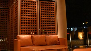 A modern interior with a brick ceiling, a wooden lattice partition, a leather sofa, and a wooden coffee table.