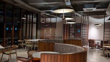 A modern interior with round tables, wooden partitions, and pendant lighting.