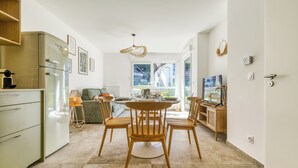 Una cocina moderna con comedor, refrigerador empotrado y un amplio ventanal con vistas al exterior.
