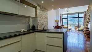 Een moderne keuken met witte kasten, een accentmuur van steen en een groot eiland.