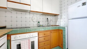 A kitchen with white cabinets, a green countertop, a sink, and a stove. - Solemar Sicilia - Terrazza del Merlo (Palermo)