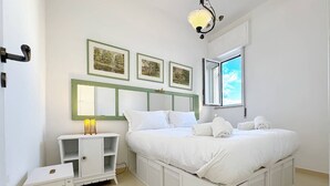 A bedroom with a bed, a nightstand, a mirror, and framed pictures on the wall. - Solemar Sicilia - Terrazza del Merlo (Palermo)