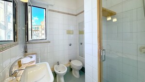 A bathroom with a sink, bidet, toilet, and a shower area. - Solemar Sicilia - Terrazza del Merlo (Palermo)