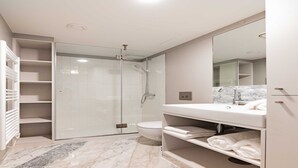 A modern bathroom with a glass-enclosed shower, a toilet, and a vanity with a mirror. - Cosy studio - Old Porto (Porto)