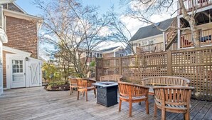 Eine Holzterrasse mit Gartenmöbeln und einem Feuerkorb.