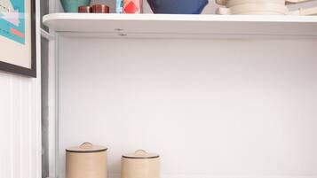 A kitchen counter with a marble top, two beige containers, a white plate, and a tablet.