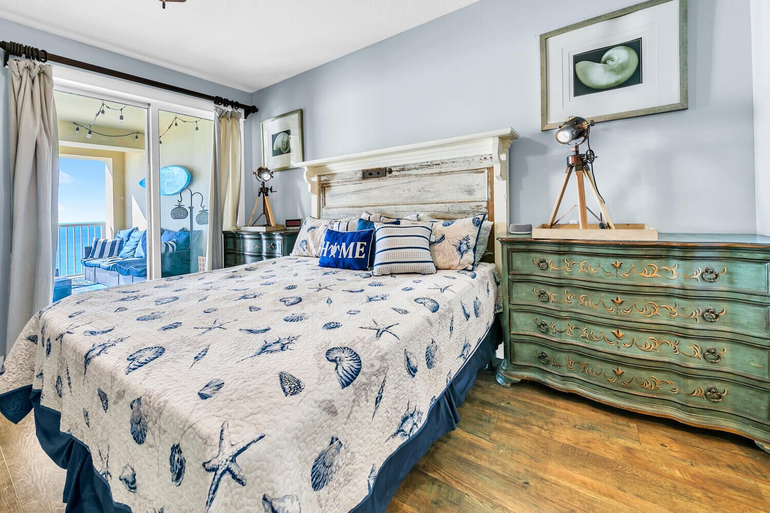 Un dormitorio con cama, cómoda y ventana con cortinas.