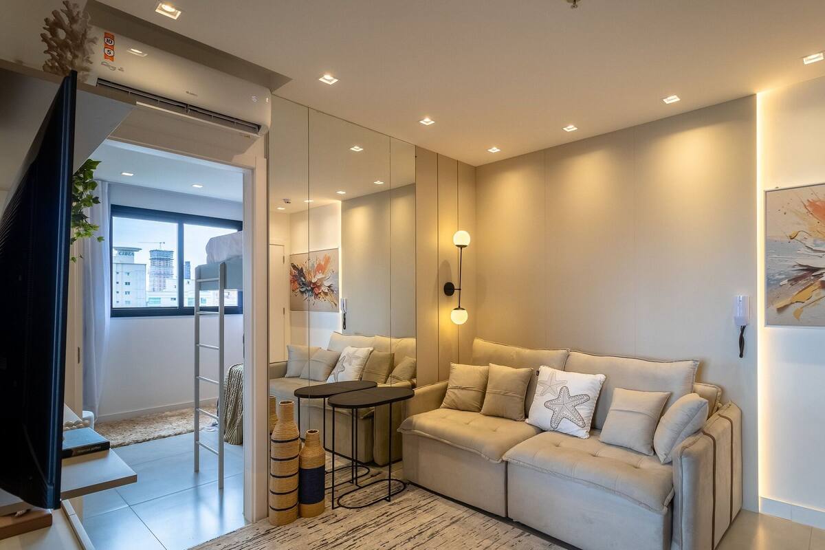 A modern living room with a sofa, a small table, and a decorative vase.