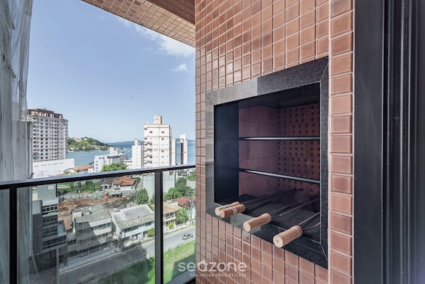 A modern room with a large window, a brick wall, and a metal shelf.