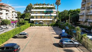 A multi-story residential building with a parking area in front.