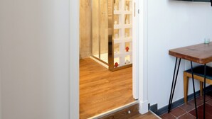 Un interno moderno con una scala in legno che conduce a una stanza con una porta in vetro.
