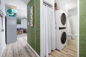 Un baño moderno con inodoro blanco, bañera y lavadora.