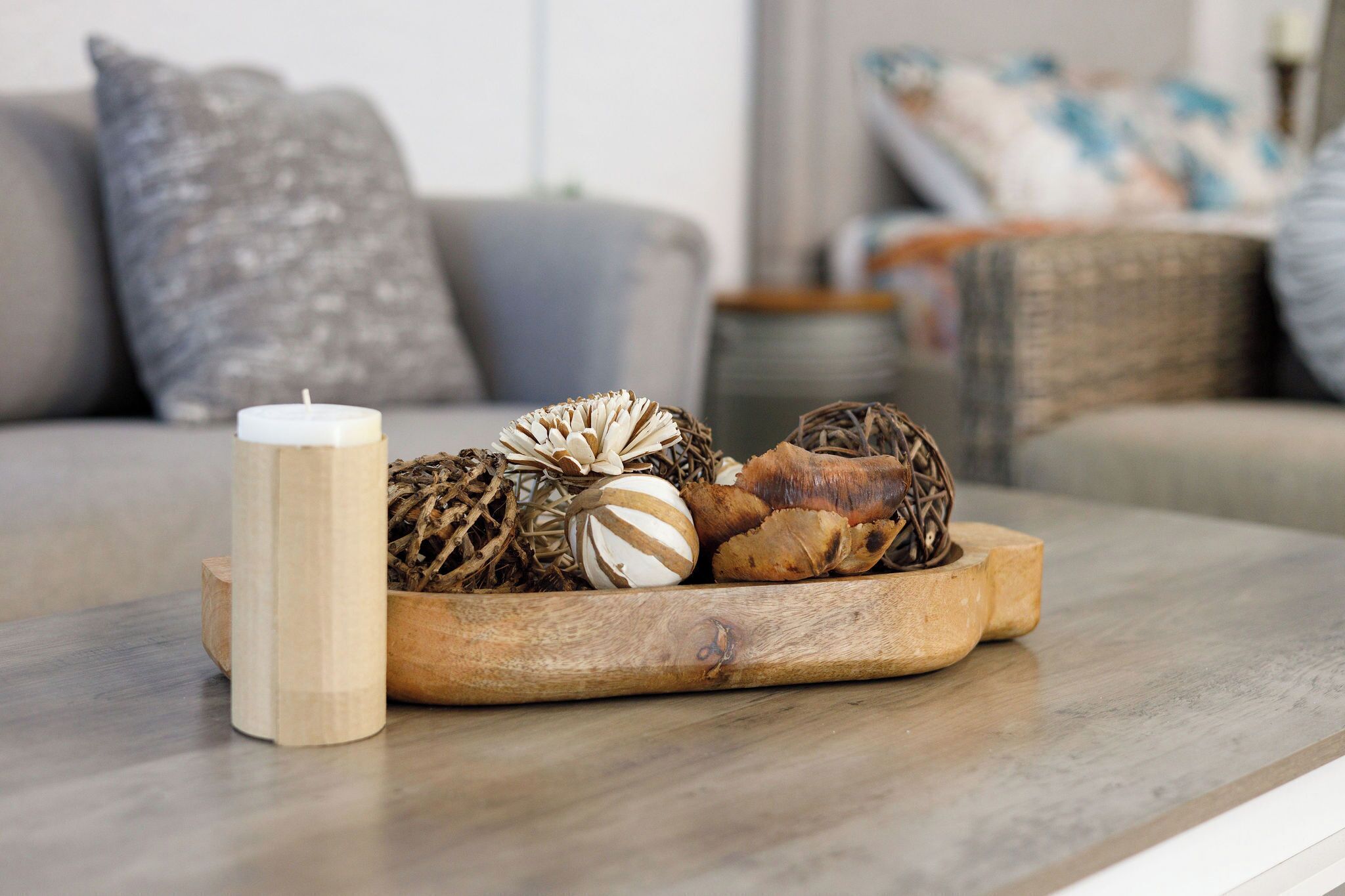 Un plateau en bois orné de divers objets décoratifs, posé sur une table dans un salon.