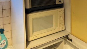 A kitchen with a microwave and a toaster oven stacked on top of each other. - Gîte du Puy des Gardes (Meymac)