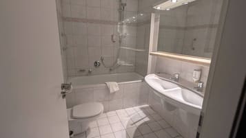 Standaard driepersoonskamer | Badkamer | Een haardroger, handdoeken, zeep, shampoo