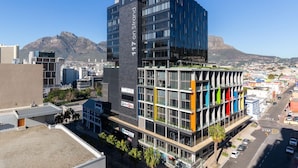 Un edificio moderno con una torre destacada y una estructura de techo plano con elementos verticales de colores.
