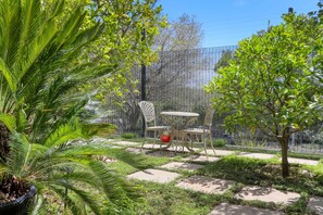 A garden area with a seating arrangement and a decorative fence. - French Country Cottage on Table Mountain (CAPE TOWN)