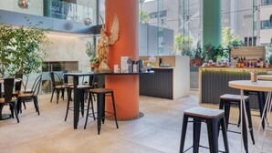 Un espace intérieur moderne doté d’un bar, de différents types de sièges et d’éléments décoratifs, comme une statue et des luminaires suspendus.