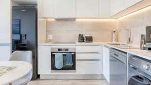 Une cuisine moderne dotée d’appareils électroménagers intégrés, d’un four encastré et d’un lave-vaisselle.