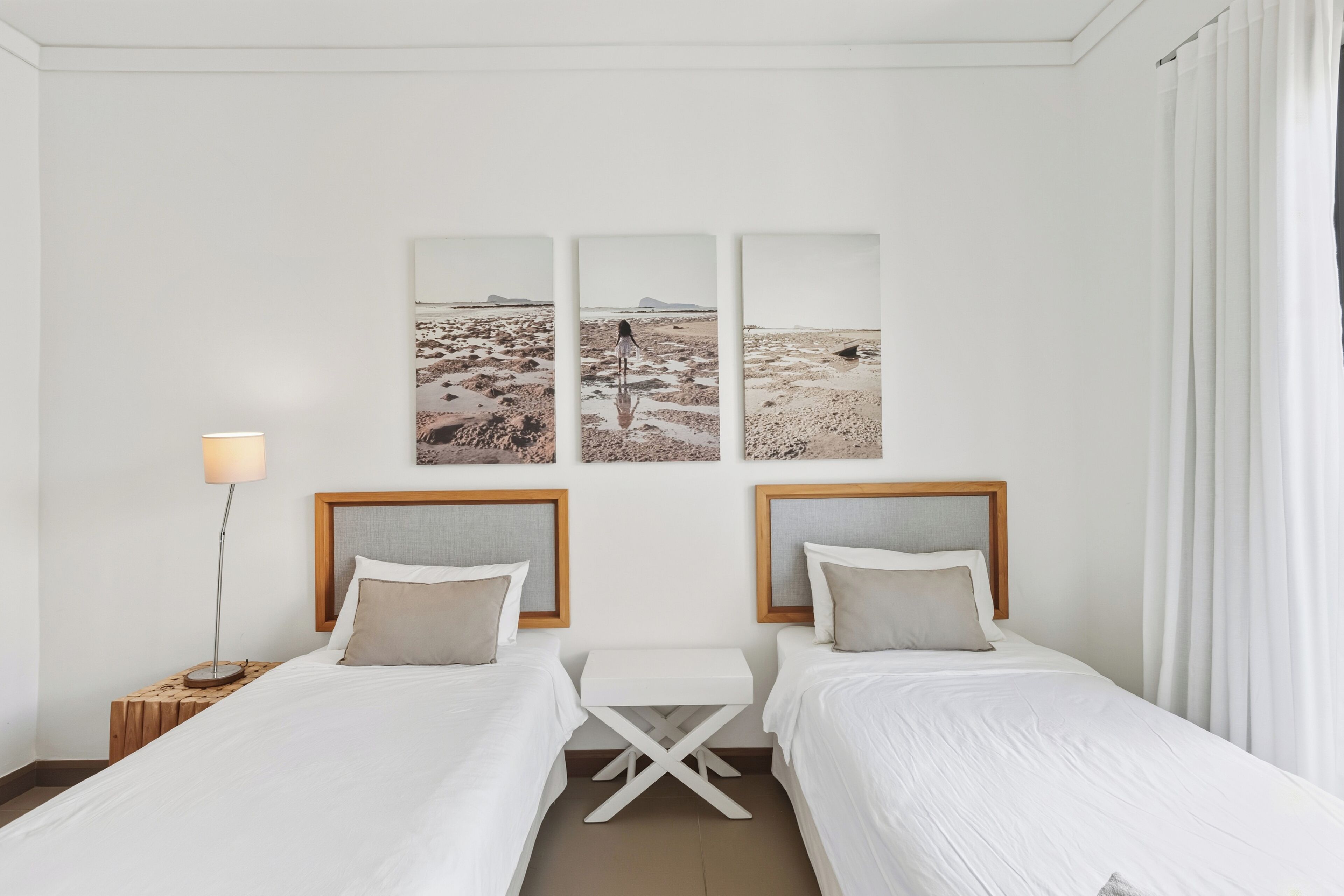 Une chambre d’hôtel avec deux lits, une petite table et une lampe.