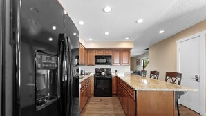 A modern kitchen with a stainless steel refrigerator, a microwave, and a stove. - Townhome w/ Private Sauna that's Close to Breck's Main Street & Bus Route! (Breckenridge)