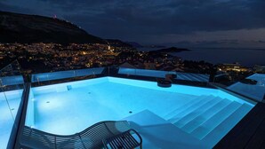 A rooftop infinity pool with steps leading down to the pool, surrounded by modern outdoor furniture. - Hedera Estate, Villa Hedera XX (Dubrovnik)