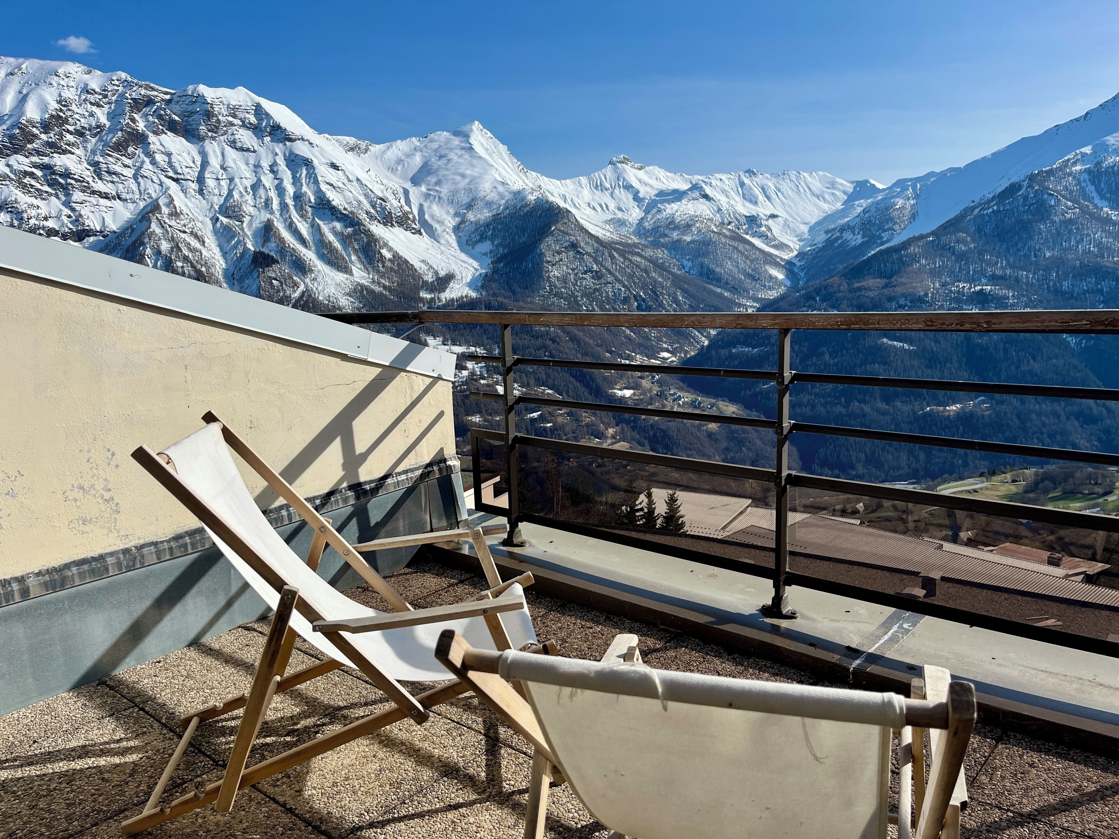 A balcony with a view of snow-covered mountains.