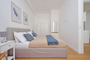Relax in this serene bedroom with a large bed, nightstand, and wardrobe.