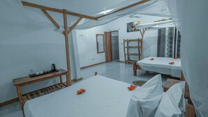 A room with two beds, a wooden bench, a table with a kettle, and a mirror on the wall. - Tuna Nungwi Beach Bungalow (Nungwi)