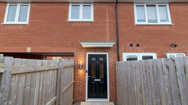 A two-story brick house with a black front door, white shutters, and a number '11' on the door. - Charming Coastal Retreat – 1-Bedroom Flat in Blyth - Pass the Keys (Blyth)