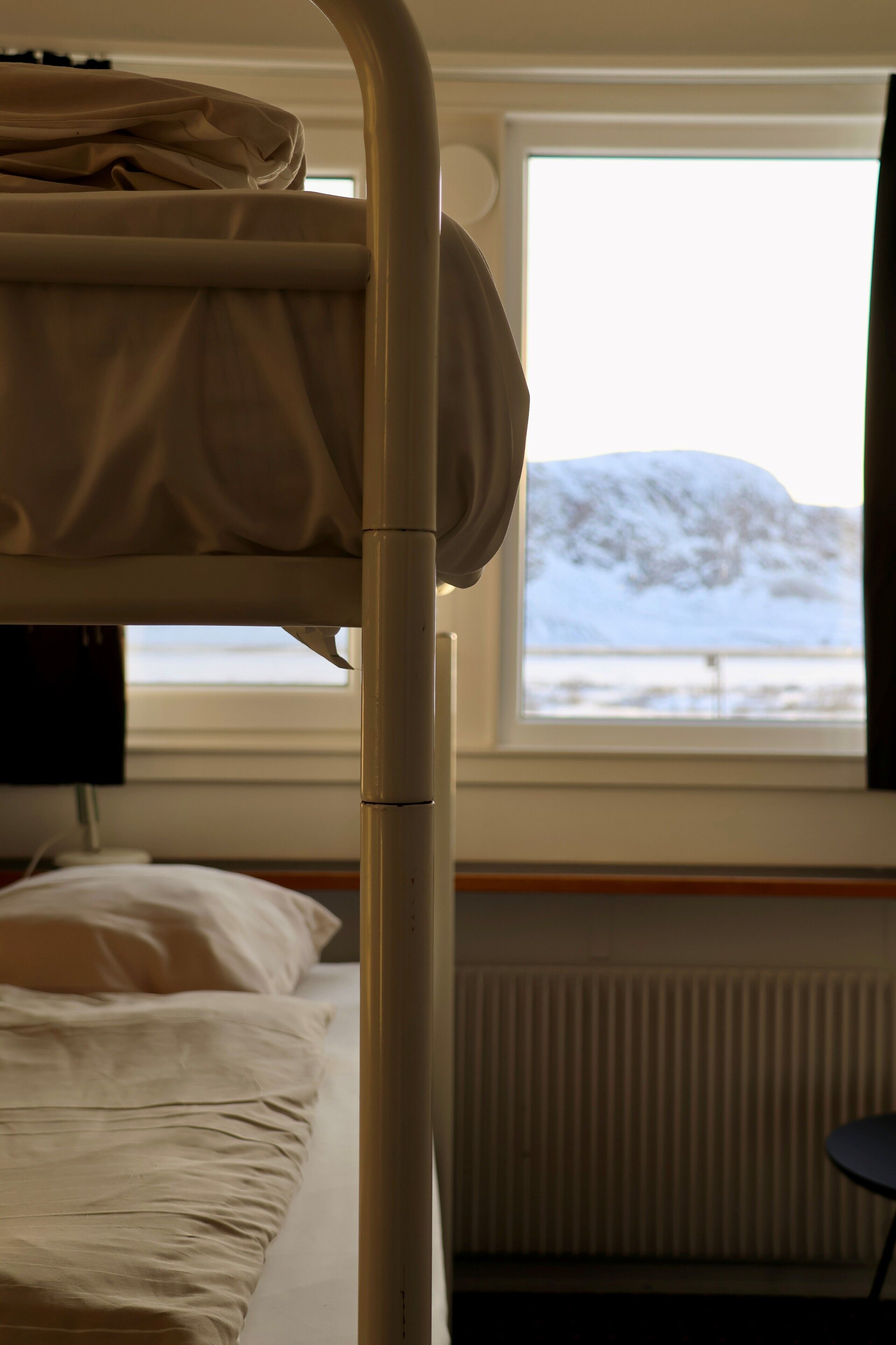 Ein Stockbett in einem Zimmer mit Fensterblick auf eine verschneite Landschaft.