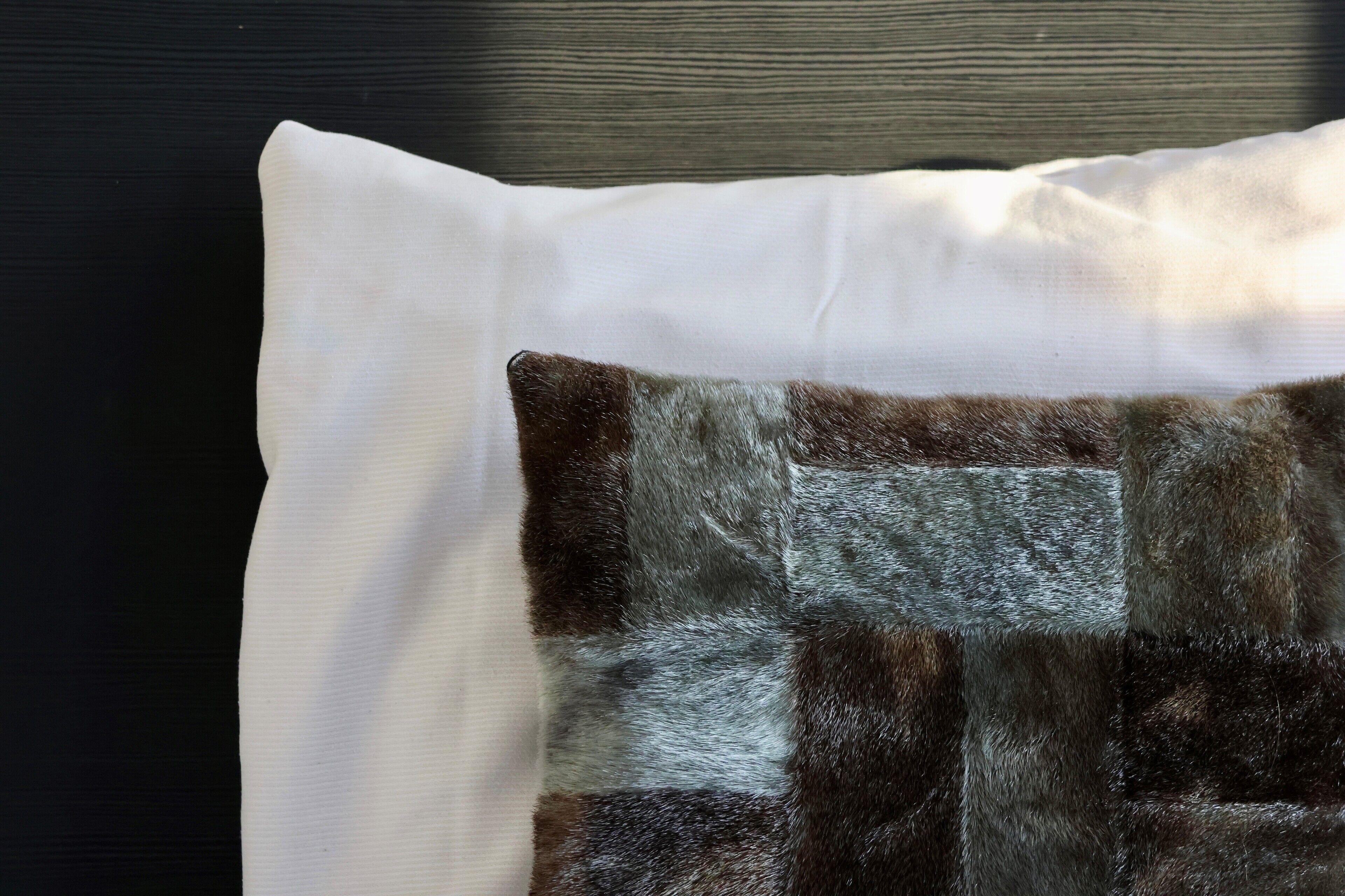 A pillow with a white and brown patchwork design.