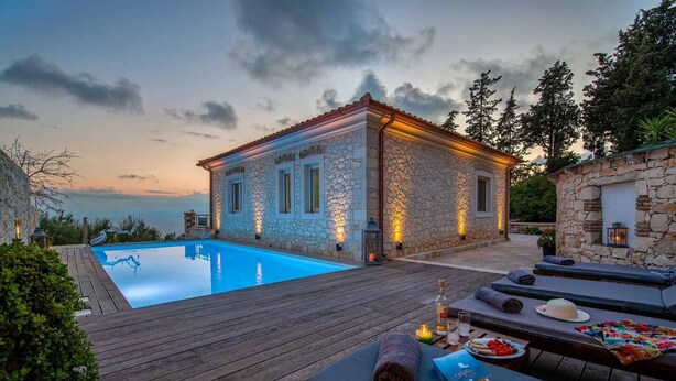 A stone building with a pool, wooden deck, and lounge area with sun loungers. - Villa Lithos in Paxi (Paxos)