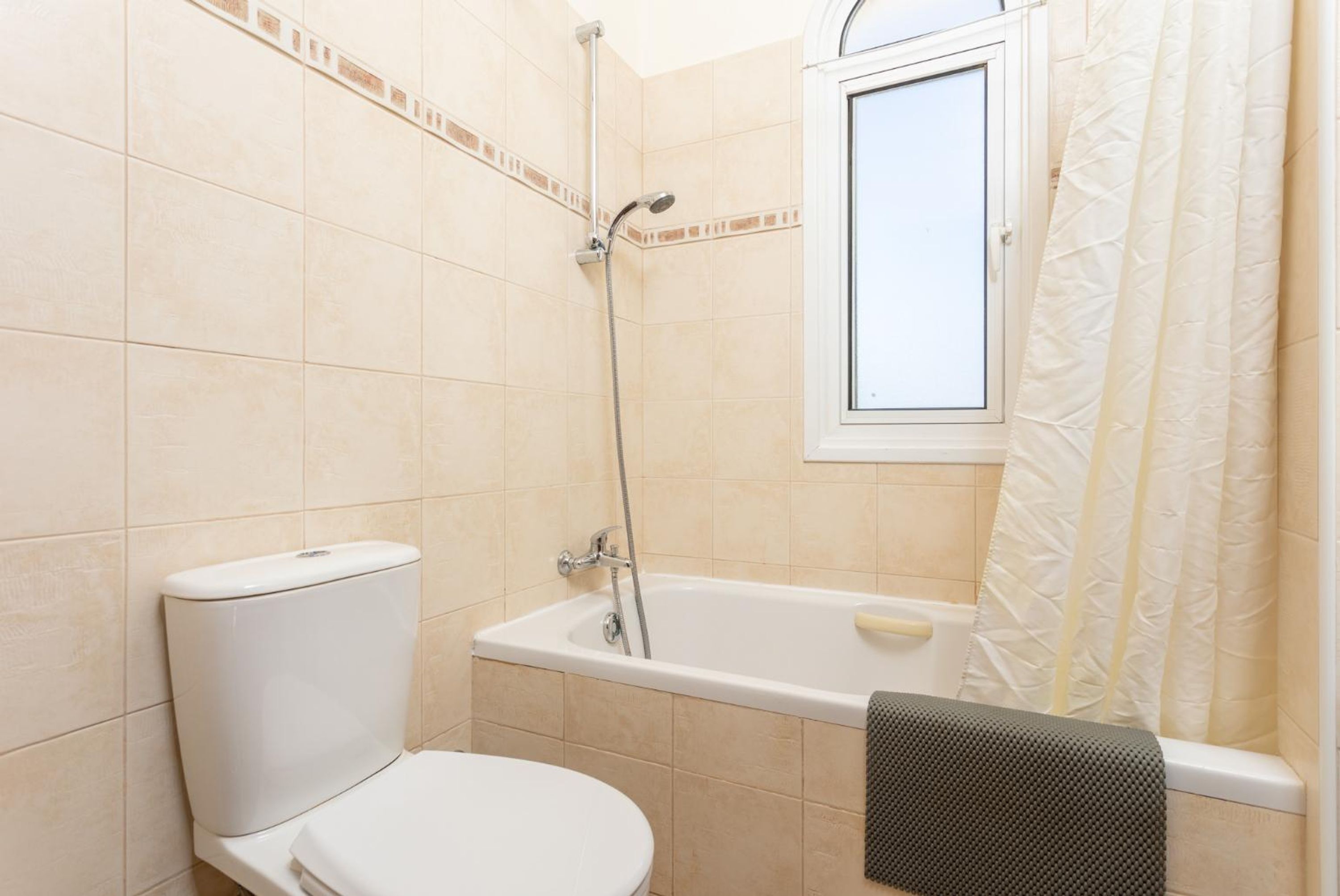 A bathroom with a toilet, a bathtub, and a shower.