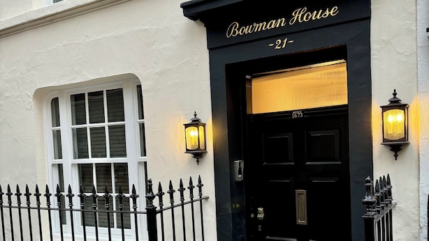 Un bâtiment avec une porte noire et l’inscription « Bowman House » au-dessus.