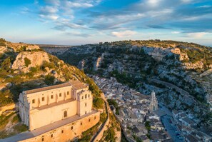 A historic town with a prominent church and fortress-like buildings on a hillside. - Villa Aziz in Scicli (Scicli)