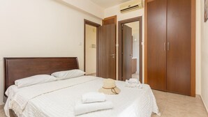 Un dormitorio con una cama grande, un armario de madera y un equipo de aire acondicionado.
