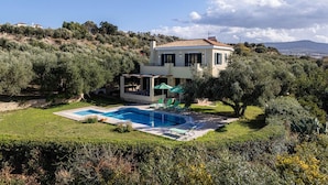 A two-story house with a swimming pool, surrounded by olive trees and a hilly landscape. - Villa Eleni in Pigianos Kampos (Rethymno)