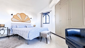 A bedroom with a bed, bedside tables, a chair, a wardrobe, and a window. - Villa Cristina 15 in Albufeira (Albufeira)