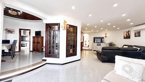 A modern living room with a black leather sofa, a white couch, and a dining area with a table and chairs. - Villa Cristina 15 in Albufeira (Albufeira)
