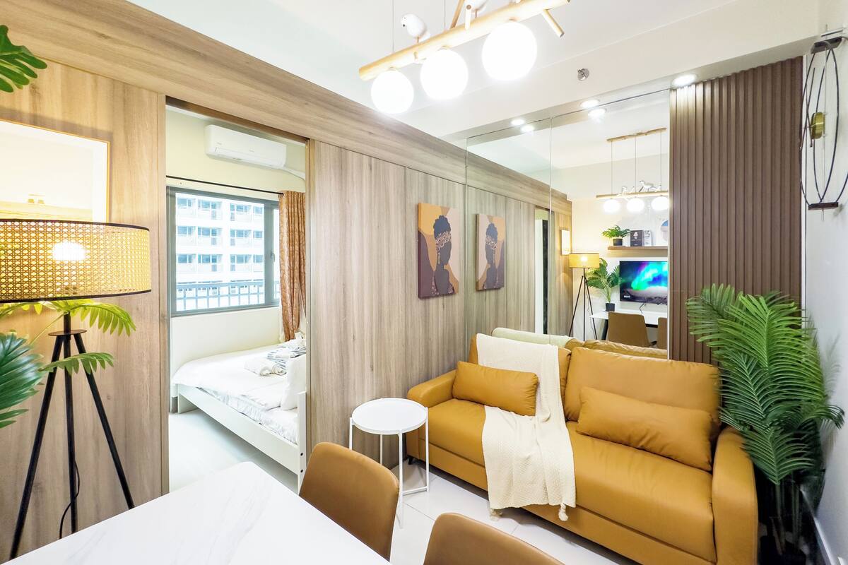 Un salon moderne avec un canapé, une petite table ronde et un lit.