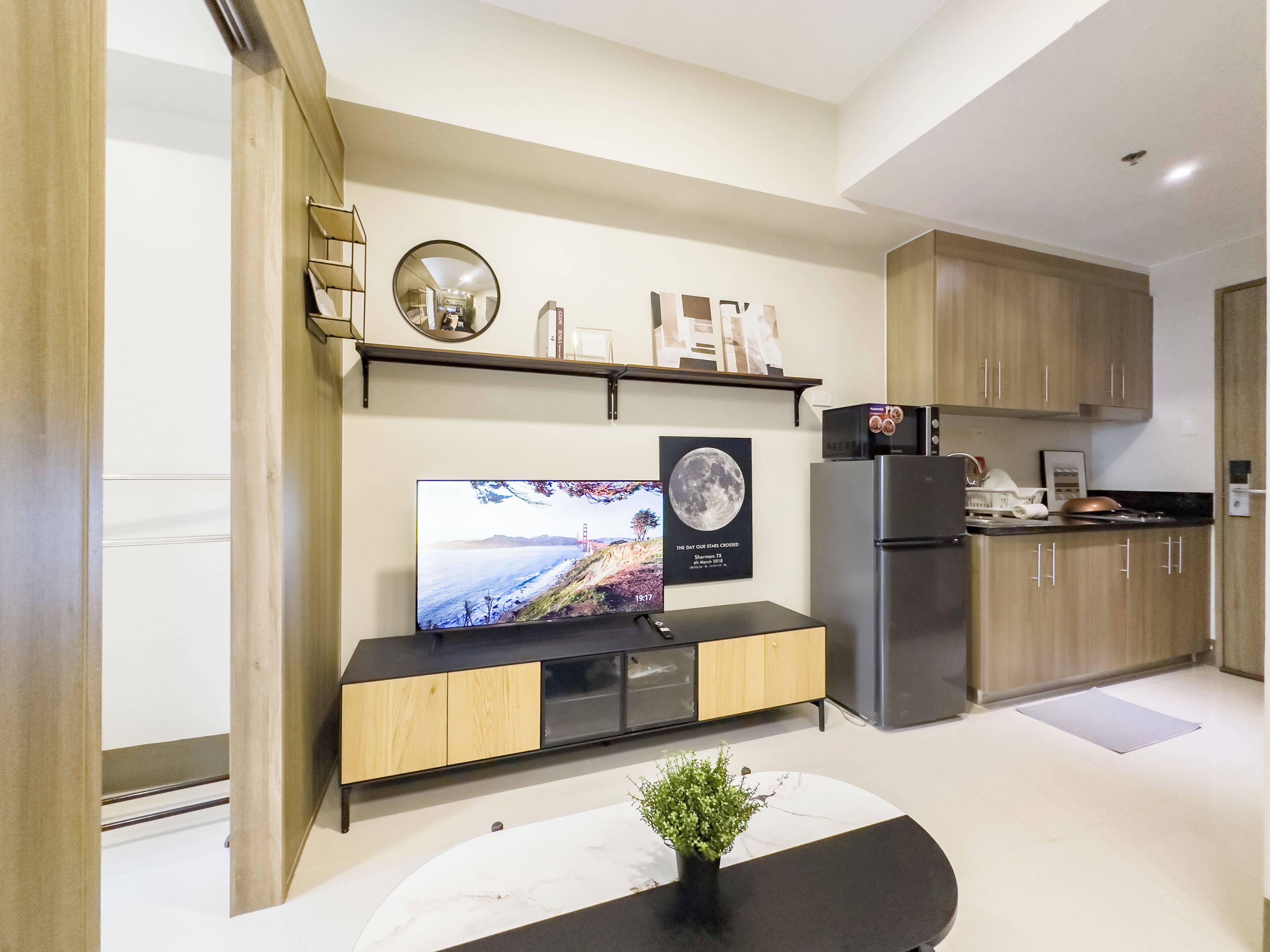 Eine moderne Küche mit eingebautem Backofen, einem Kühlschrank und einem Holzkasten.
