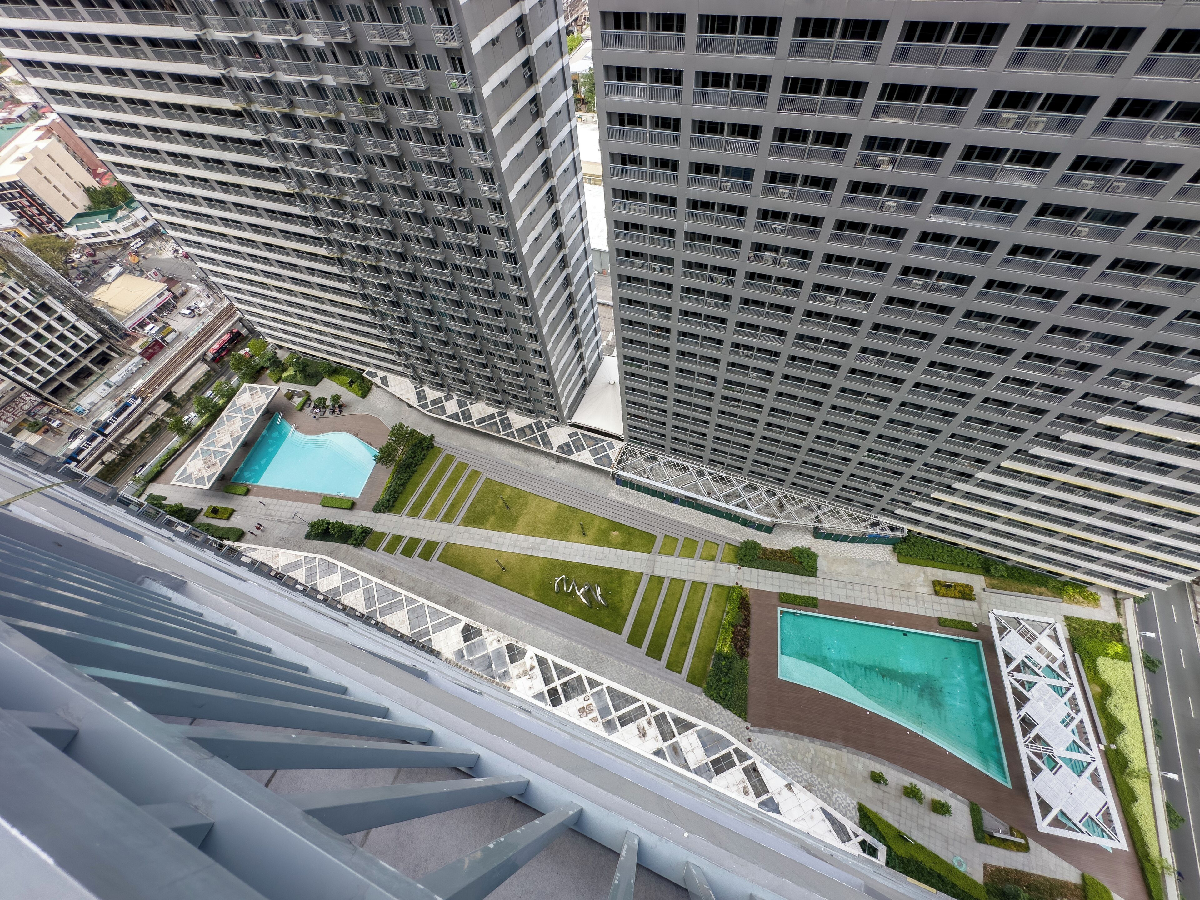 Un immeuble de grande hauteur doté de nombreux balcons, d’une piscine et d’un espace paysager agrémenté de sentiers.