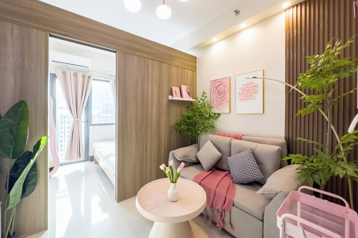 Un salon moderne avec un canapé, une table ronde et une plante en pot.