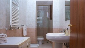 Ein kleines Badezimmer mit Waschmaschine, Toilette und Waschbecken.