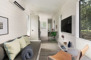 A modern interior with a sofa, a dining area, and a kitchen.