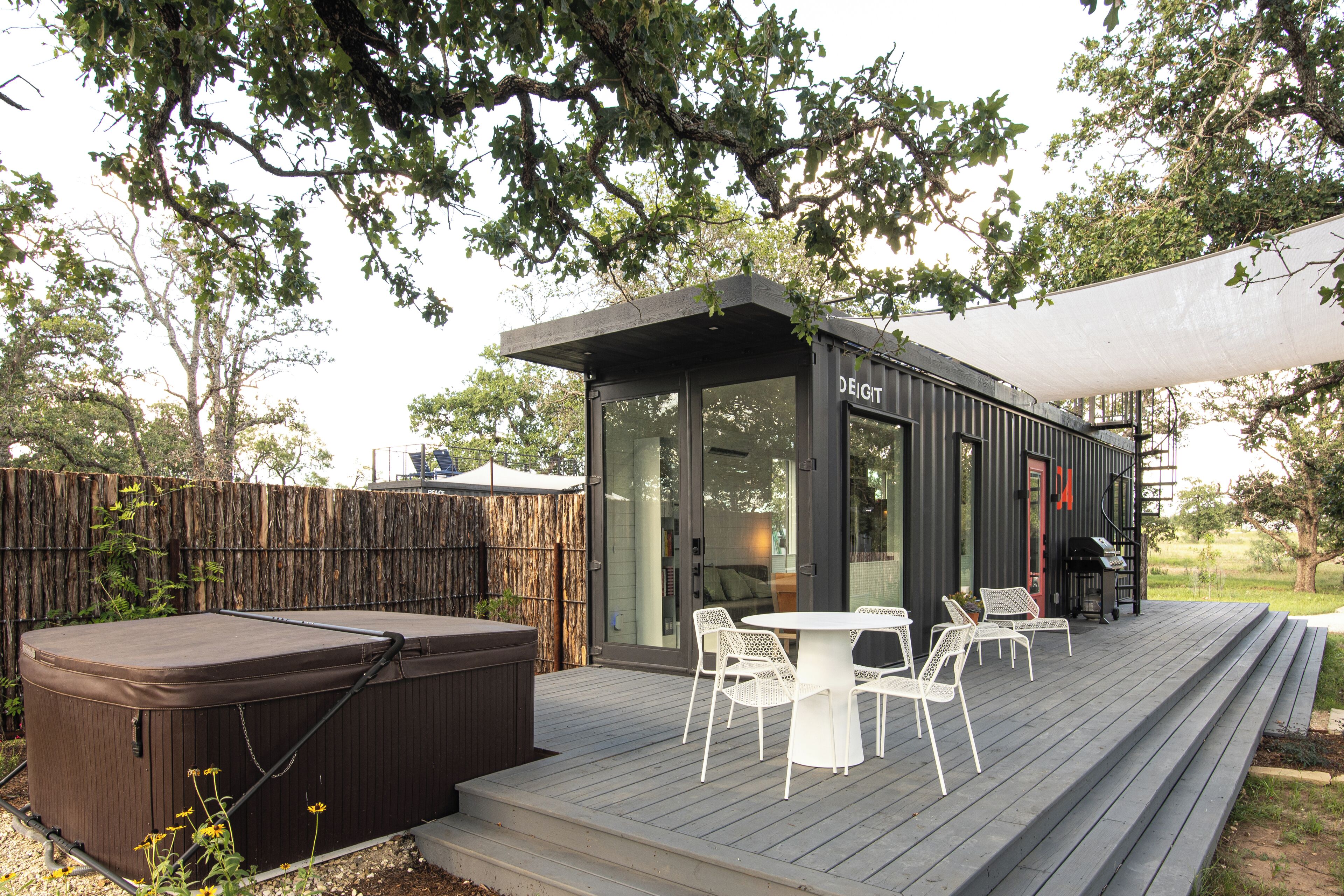 A hot tub, outdoor seating, and a covered patio area.